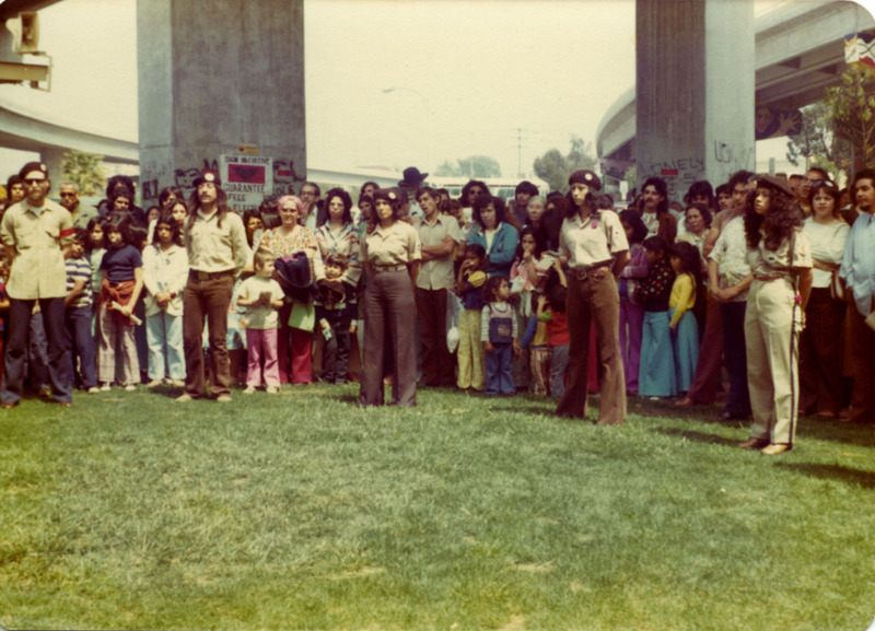 Brown Berets y un multitud en el Parque Chicano. / Brown Berets and a crowd at Chicano Park.