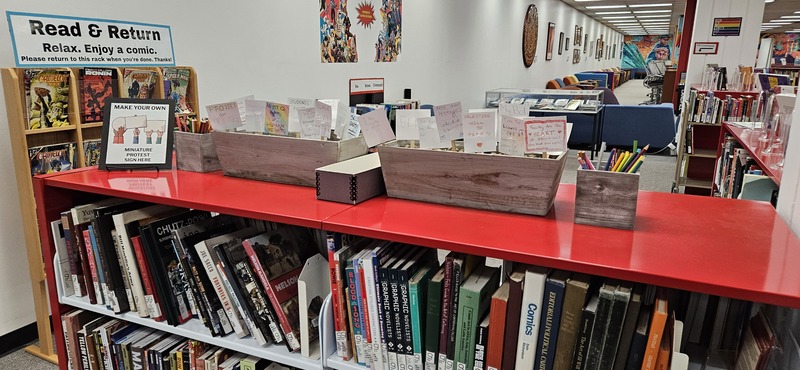 Image from the physical exhibit that shows display cases and wallpaper