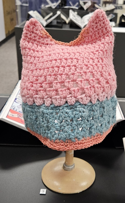 A pick Crocheted hat with blue trim