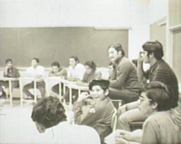 Estudiantes universitarios en un salón de clases. / College students in a classroom.