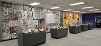 Image from the physical exhibit that shows display cases and wallpaper