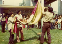 Los Brown Berets levantan una bandera en el Parque Chicano. / The Brown Berets raise a flag at Chicano Park.