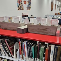 Image from the physical exhibit that shows display cases and wallpaper