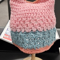 A pick Crocheted hat with blue trim