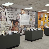 Image from the physical exhibit that shows display cases and wallpaper