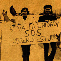 Dos manifestantes con un afiche. / Two protesters holding a sign.